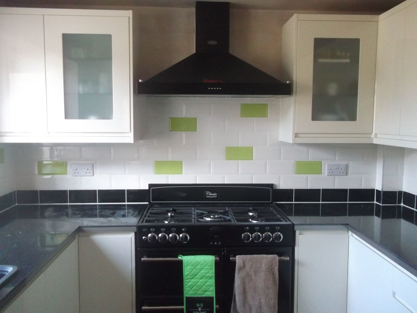 Kitchen splashback in white metro tiles behind a range cooker