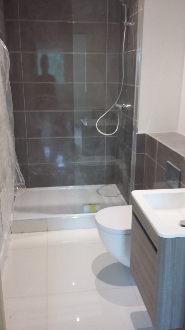 Shower enclosure tiled in grey with recessed fittings